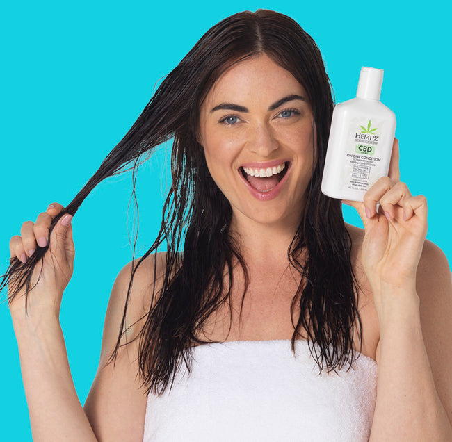 Model holding hair and CBD conditioner